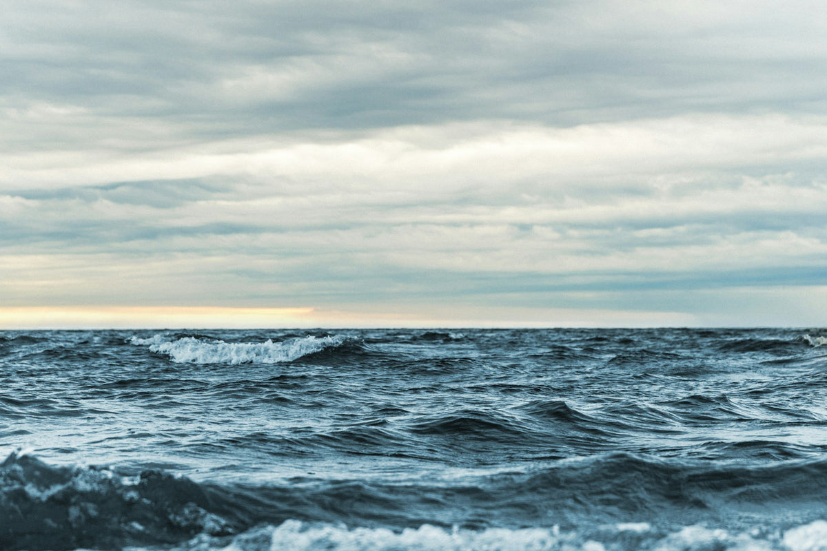 Ocean swell rolling toward shore under a sky of clouds