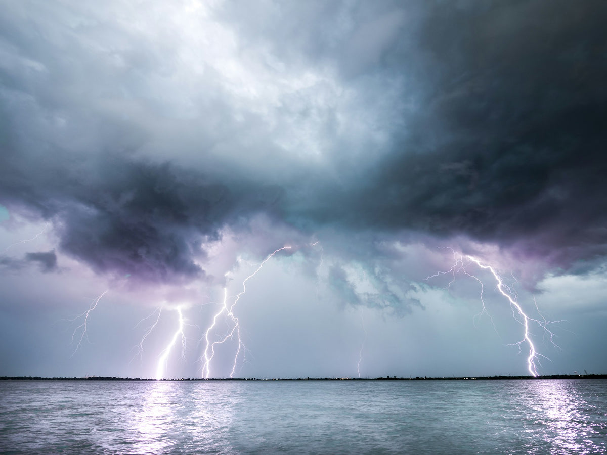 Lightning bolt striking over a dark body of water