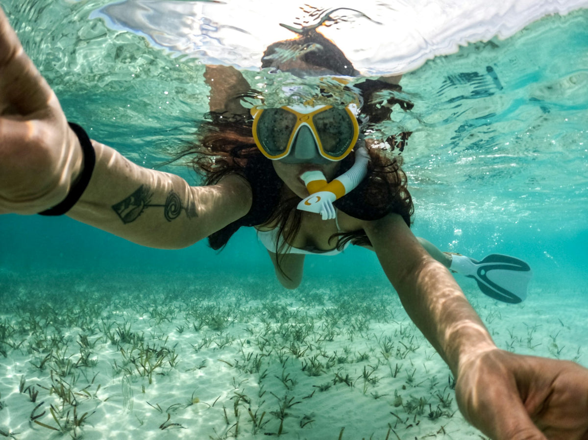 Woman snorkeling at the surface of clear blue ocean water