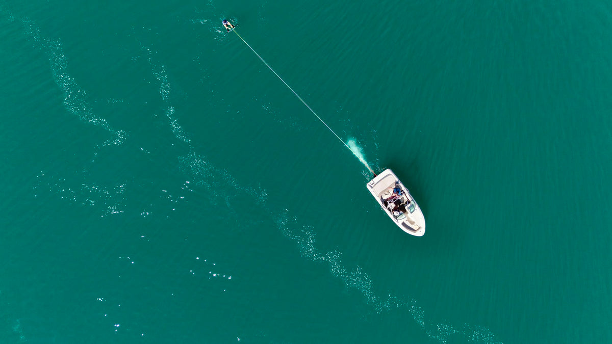 White boat pulling a tow rope across turquoise water