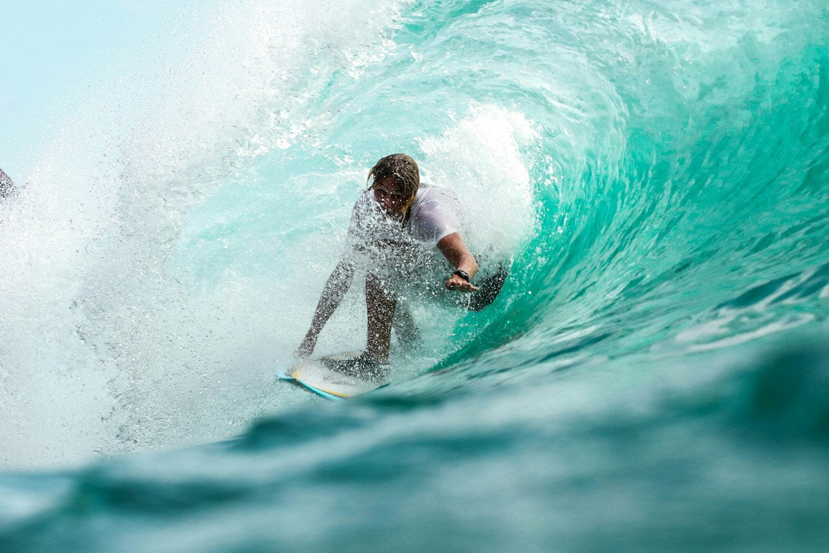 Surfer riding a turquoise wave