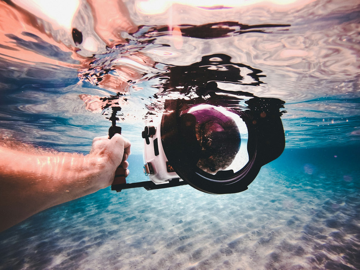 Person holding a white and black underwater camera
