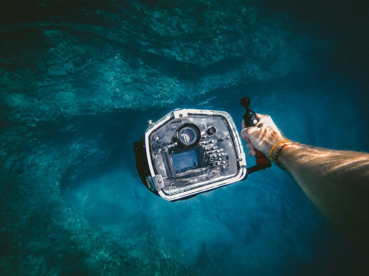 Person holding a camera underwater