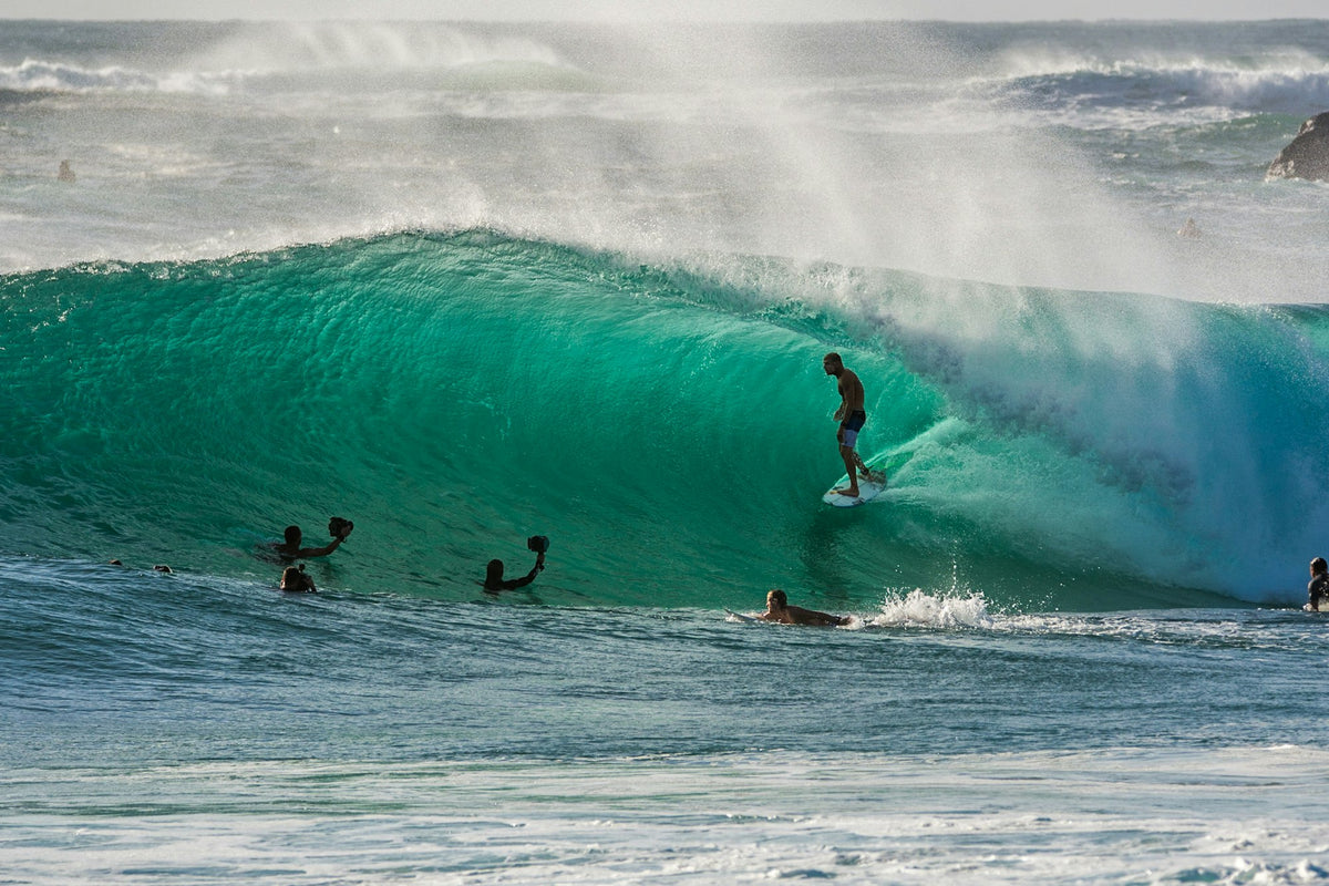 Several surfers in the water riding and waiting for waves