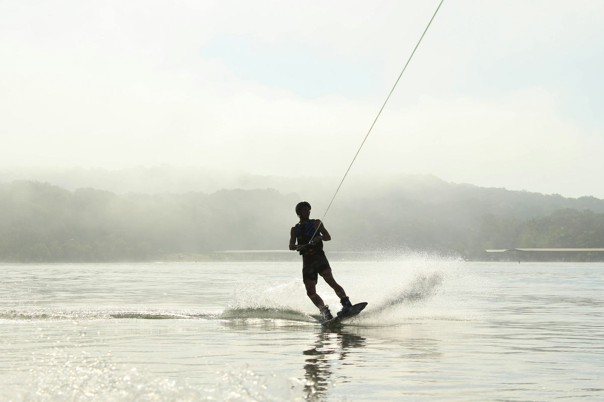Rider holding a tow rope while surfing a boat wake