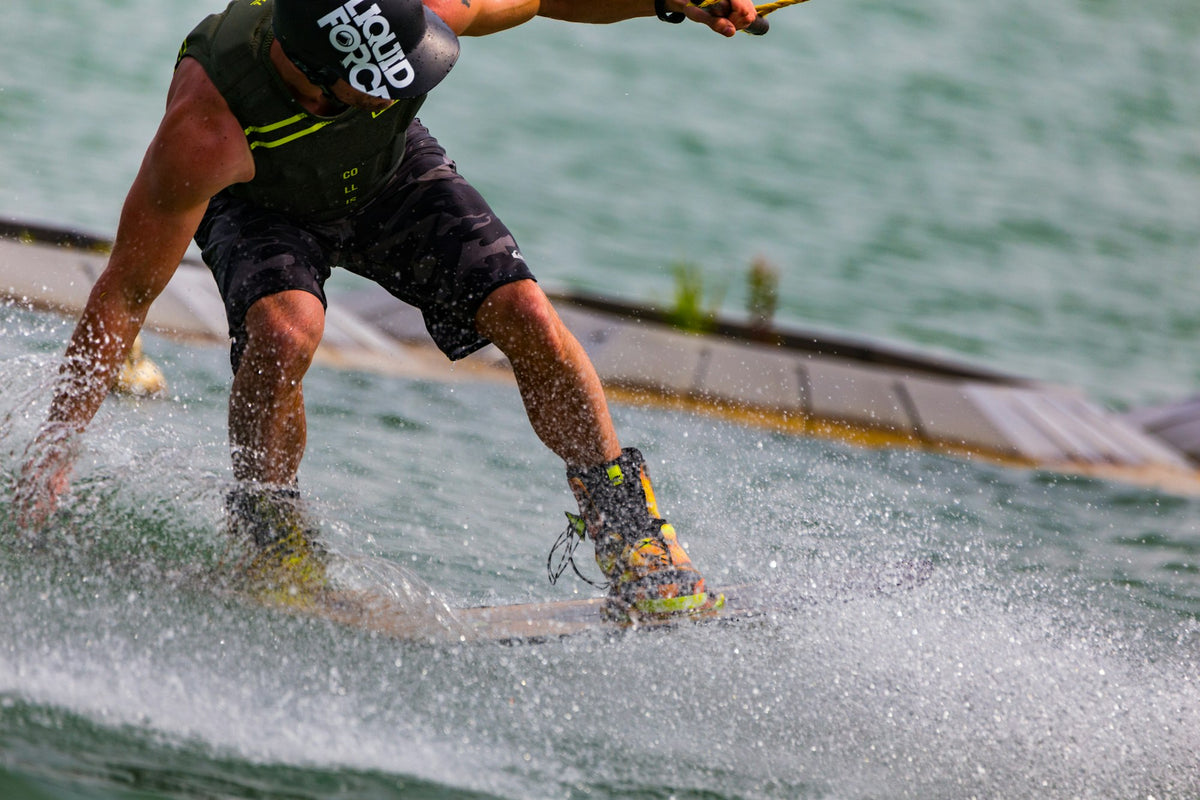 Rider gliding across shallow water on a skimboard at the beach