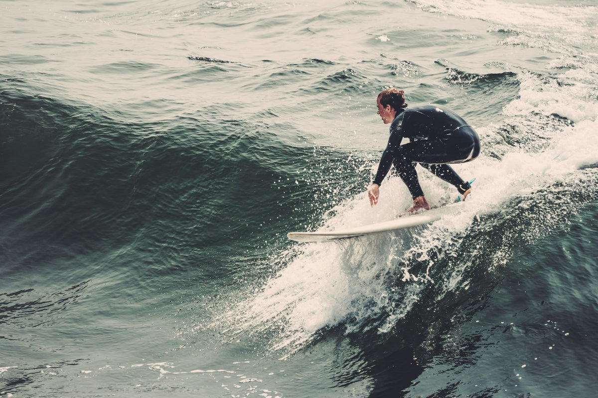 Surfer in a black full wetsuit riding a wave