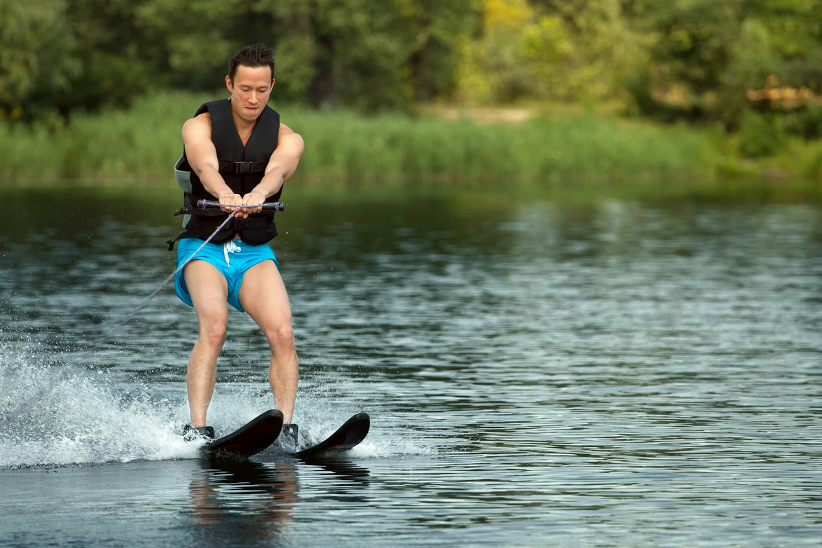 Water skier carving across a lake behind a boat